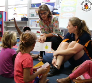 Margaret encouraging children in the Central Desert with reading and listening in their first language.